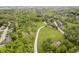 Aerial view of property with long driveway, barn, pool, surrounded by lush trees at 10627 Indian Lake S Blvd, Indianapolis, IN 46236