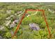 Aerial view of a luxury property outlined in red with a pool, greenery, and a long driveway at 10627 Indian Lake S Blvd, Indianapolis, IN 46236