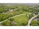 Aerial view of neighborhood with long driveway and barn, in lush green setting at 10627 Indian Lake S Blvd, Indianapolis, IN 46236