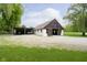 Exterior view of barn with covered parking, gravel driveway, grass surround and trees at 10627 Indian Lake S Blvd, Indianapolis, IN 46236