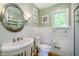 Classic bathroom featuring a pedestal sink, wainscoting, and a large window at 10627 Indian Lake S Blvd, Indianapolis, IN 46236