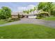 Charming brick home featuring a large driveway, three-car garage, and mature trees at 10627 Indian Lake S Blvd, Indianapolis, IN 46236