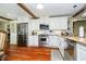 Modern kitchen with white cabinets, stainless steel appliances, and hardwood floors at 10627 Indian Lake S Blvd, Indianapolis, IN 46236