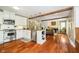 Open kitchen featuring stainless steel appliances, white cabinetry, and hardwood floors at 10627 Indian Lake S Blvd, Indianapolis, IN 46236