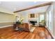 Inviting living room with hardwood floors, a fireplace, and a large window providing lots of natural light at 10627 Indian Lake S Blvd, Indianapolis, IN 46236