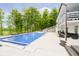 Inviting backyard pool with patio, lounge seating and a verdant treeline in background at 10627 Indian Lake S Blvd, Indianapolis, IN 46236