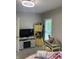 Bright bedroom with ceiling fan, desk, and large television at 1114 N Olney St, Indianapolis, IN 46201