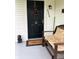 Inviting front porch with a bench, wreath, and decorative lion statue by the door at 1114 N Olney St, Indianapolis, IN 46201