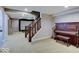 Finished basement with elegant staircase, a home theater setup, and a vintage piano, offering versatile living space at 11521 Willow Bend Dr, Zionsville, IN 46077