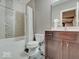 Cozy bathroom featuring a shower-tub combo, mosaic tile accents, and a single sink vanity with dark wood cabinets at 11521 Willow Bend Dr, Zionsville, IN 46077