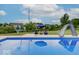 Backyard pool features a slide, basketball hoop, and seating areas, perfect for outdoor entertainment and Gathering fun at 11521 Willow Bend Dr, Zionsville, IN 46077
