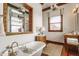 Bright bathroom featuring a freestanding tub with gold fixtures, wood vanity, and custom shelving with decor at 11705 N Shelby 700 W, New Palestine, IN 46163