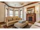 Elegant living room features a cozy fireplace, detailed ceiling, and natural light from surrounding windows at 11705 N Shelby 700 W, New Palestine, IN 46163