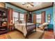 Inviting main bedroom with blue walls, patterned curtains, four poster bed, and vintage furniture at 11705 N Shelby 700 W, New Palestine, IN 46163