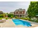 This two-story brick home boasts a refreshing in-ground pool and meticulously maintained landscaping at 11705 N Shelby 700 W, New Palestine, IN 46163