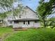 A view of the back of the house, showing the siding and basic structure, with surrounding trees at 1247 Wright St, Indianapolis, IN 46203