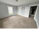 Neutral carpeted bedroom features a white-trimmed window, door and light grey walls at 1247 Wright St, Indianapolis, IN 46203