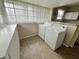Bright laundry room area with washer, dryer, and overhead shelving at 1247 Wright St, Indianapolis, IN 46203