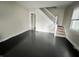 Spacious living room with dark hardwood floors, complemented by a staircase and natural light at 1247 Wright St, Indianapolis, IN 46203