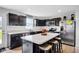 Modern kitchen features dark cabinets, stainless steel appliances and an island with bar seating and marble countertop at 13887 N Hawkers Hill Dr, Camby, IN 46113