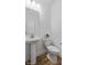 Simple half-bathroom features a modern pedestal sink, toilet, and hardwood-style floors at 14866 E Keenan Cir # Lot 38, Westfield, IN 46074