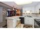 A well-lit kitchen with sleek white cabinets and a bar counter at 1602 Queensbridge Sq # 7, Indianapolis, IN 46219