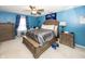 Main bedroom with blue walls, ceiling fan and beautifully ornate wooden furniture at 1602 Queensbridge Sq # 7, Indianapolis, IN 46219