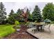 View of outdoor dining table and chairs amongst mature trees and landscaping at 16126 Etna Green, Westfield, IN 46074