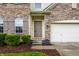 Close-up of the home's entrance with decorative shrubs, brick accents, and a tidy walkway at 16126 Etna Green, Westfield, IN 46074