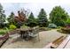 Landscaped patio area with an ornate outdoor dining table and chair set amongst mature plantings at 16126 Etna Green, Westfield, IN 46074