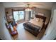 Neutral bedroom featuring a window, desk, and stylish furnishings, illuminated by a modern ceiling fan at 1713 Williamsburg Cir, Franklin, IN 46131