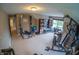 The expansive bonus room includes workout equipment, seating and a wall of built-in shelving at 1713 Williamsburg Cir, Franklin, IN 46131