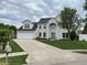 A beautiful white brick two-story home with a large driveway and well-manicured lawn at 1713 Williamsburg Cir, Franklin, IN 46131