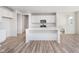 Bright kitchen featuring an island, wood grain flooring, stainless steel appliances, and white cabinets at 18967 Seaforth Way, Westfield, IN 46074