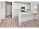 Bright kitchen featuring an island, wood grain flooring, stainless steel appliances, and white cabinets at 18967 Seaforth Way, Westfield, IN 46074