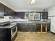 An outdated kitchen with black cabinets and laminate countertops at 2006 N Olney St, Indianapolis, IN 46218