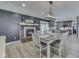 Dining area featuring a decorative fireplace, modern lighting, and view into an updated kitchen at 2010 Alexandria Dr, Greenfield, IN 46140