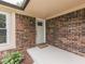 Exterior view of the front door with brick siding, a welcome mat, and attractive landscaping at 2010 Alexandria Dr, Greenfield, IN 46140