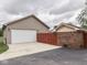 Spacious garage with a large white door, ample parking on a concrete driveway, and privacy fence at 2010 Alexandria Dr, Greenfield, IN 46140