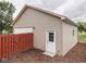 This garage features a white door and access door along with vinyl siding and privacy fence at 2010 Alexandria Dr, Greenfield, IN 46140