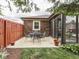 Cozy patio next to a sunroom with a round metal table, chairs, landscaping, and a privacy fence at 2010 Alexandria Dr, Greenfield, IN 46140