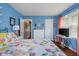 Bright bedroom with floral bedding and blue walls offers a comforting and welcoming atmosphere at 2021 Chestnut St, Columbus, IN 47201
