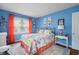 Inviting bedroom with bold blue walls, floral bedding, and a decorative lamp, creating a comfortable retreat at 2021 Chestnut St, Columbus, IN 47201