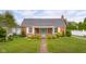 Charming brick home featuring a well-manicured lawn and inviting front porch with a swing at 2021 Chestnut St, Columbus, IN 47201