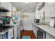 Galley kitchen with stainless steel appliances, white cabinets, and a bright blue rug adding a pop of color at 2021 Chestnut St, Columbus, IN 47201