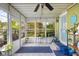 Bright sunroom features tiled floors, multiple windows, and a ceiling fan for comfort and views of the back porch at 2021 Chestnut St, Columbus, IN 47201