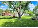 A lush green backyard featuring an mature tree, a garden, and a lawn perfect for relaxation and outdoor activities at 2110 Fisher Ave, Speedway, IN 46224