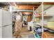 Unfinished basement utility area with storage shelves, laundry appliances, and utility access at 2110 Fisher Ave, Speedway, IN 46224