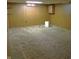Unfinished basement area features paneled walls and carpeting with a small storage cabinet at 2110 Fisher Ave, Speedway, IN 46224
