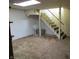 Unfinished basement with carpeted stairs, white walls, and neutral carpet, providing a blank canvas for future customization at 2110 Fisher Ave, Speedway, IN 46224